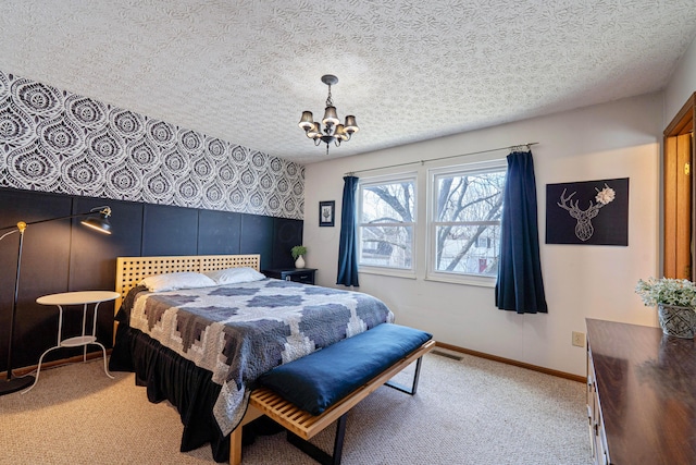 bedroom with light carpet, an inviting chandelier, baseboards, and a textured ceiling