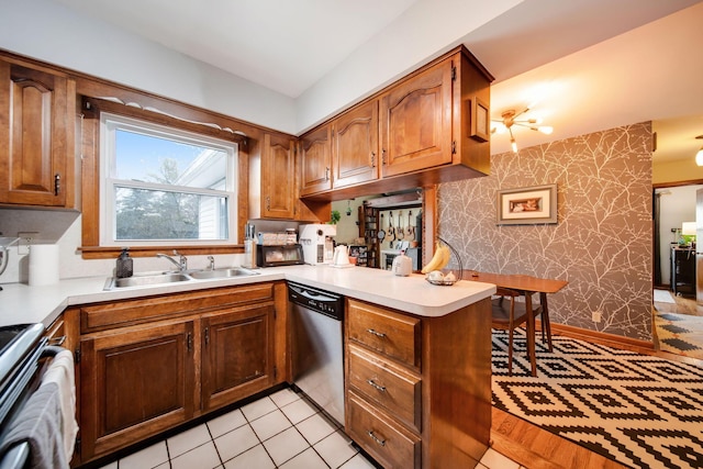 kitchen featuring stainless steel dishwasher, kitchen peninsula, sink, and stove