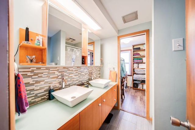 bathroom featuring vanity, hardwood / wood-style floors, and decorative backsplash