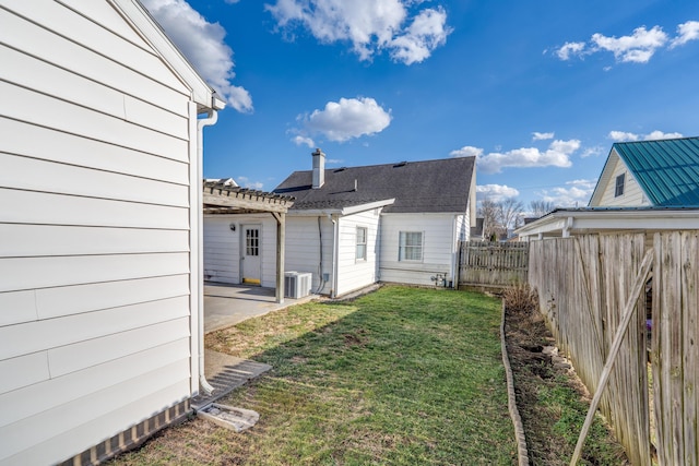 view of yard featuring cooling unit, fence, and a patio