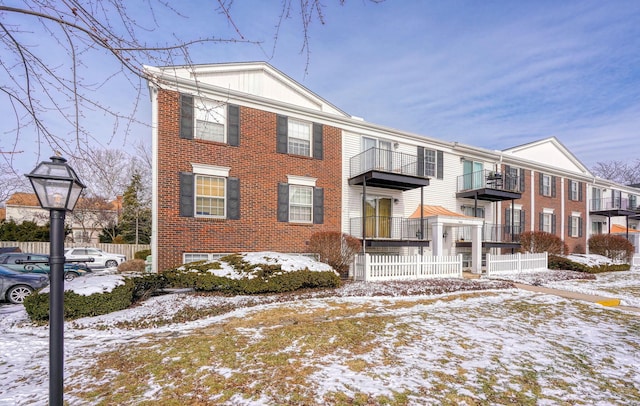 view of front of house with brick siding and fence