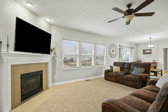 carpeted living room featuring ceiling fan, a fireplace, and a textured ceiling