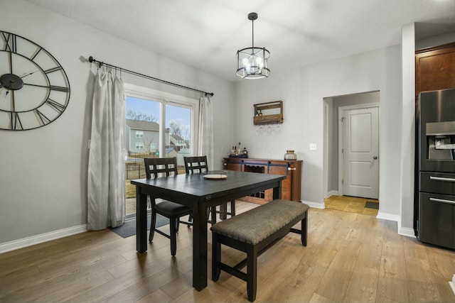 dining area with a chandelier and light wood-type flooring