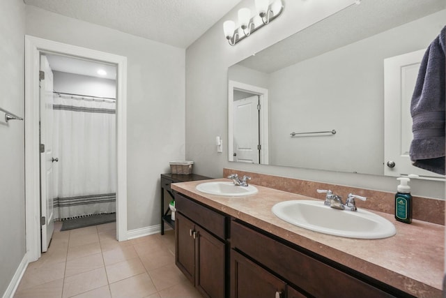 bathroom with tile patterned flooring, vanity, curtained shower, and a textured ceiling