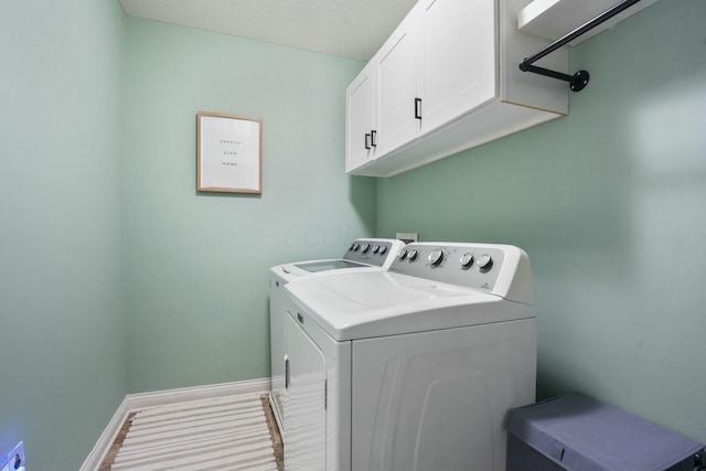 laundry area featuring cabinets, washer and dryer, and a textured ceiling