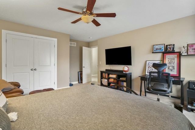 carpeted bedroom featuring ceiling fan and a closet