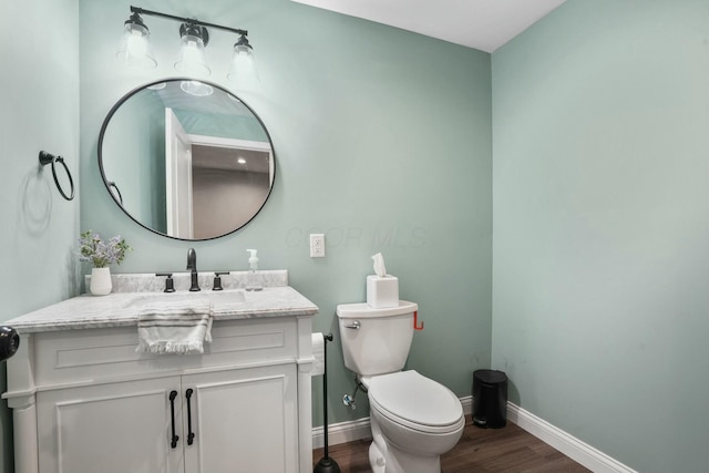 bathroom with hardwood / wood-style flooring, vanity, and toilet