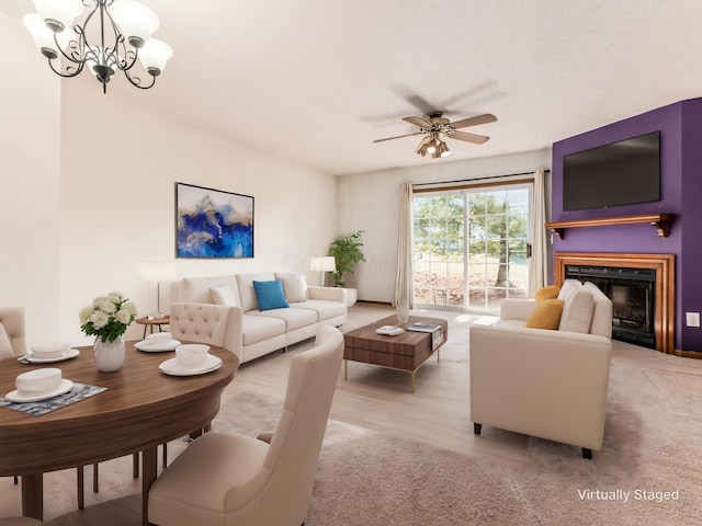 living room with light hardwood / wood-style floors and ceiling fan with notable chandelier