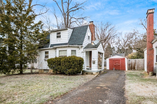 view of front of home with a front yard and a storage shed