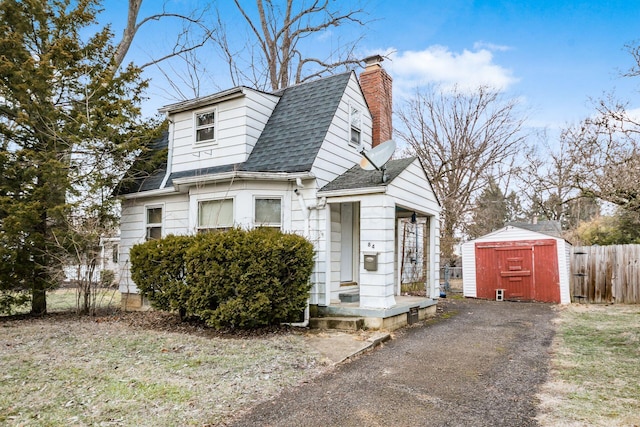 bungalow-style house featuring a storage unit