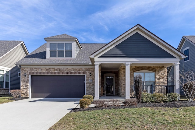 view of front facade featuring concrete driveway, stone siding, roof with shingles, an attached garage, and covered porch