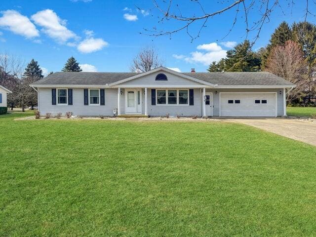 ranch-style house featuring a front yard, an attached garage, and driveway