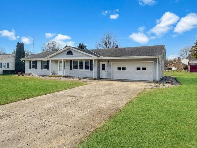 ranch-style house featuring a front lawn, an attached garage, and driveway