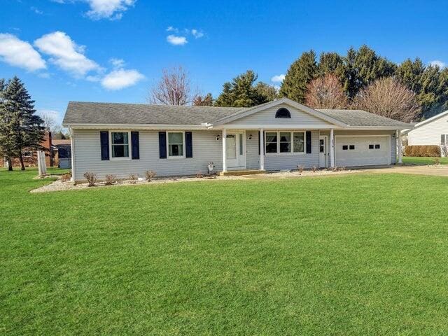 ranch-style home featuring a garage, driveway, and a front yard