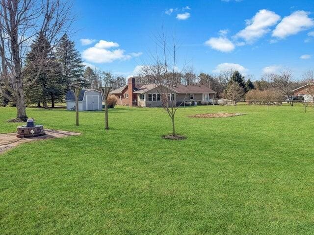 view of yard featuring a storage shed and an outdoor structure