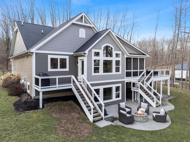 rear view of property featuring a deck, a patio, a fire pit, a sunroom, and stairs