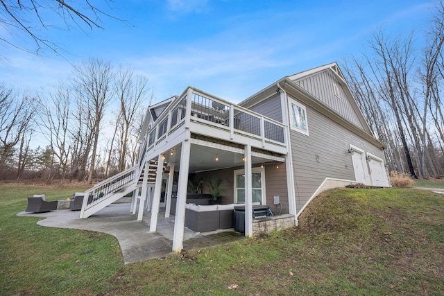 back of house with a yard, a patio, board and batten siding, a garage, and an outdoor living space