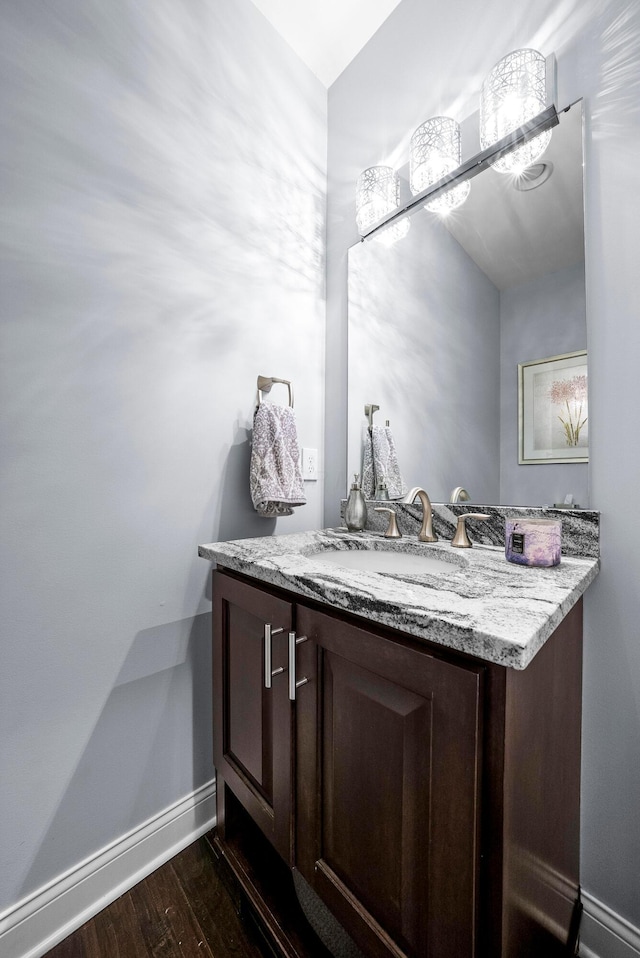 bathroom featuring baseboards, wood finished floors, and vanity