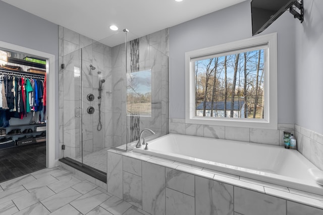 bathroom featuring a garden tub, recessed lighting, marble finish floor, a spacious closet, and a shower stall