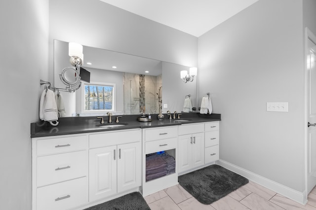 full bath with a sink, a shower stall, baseboards, and double vanity