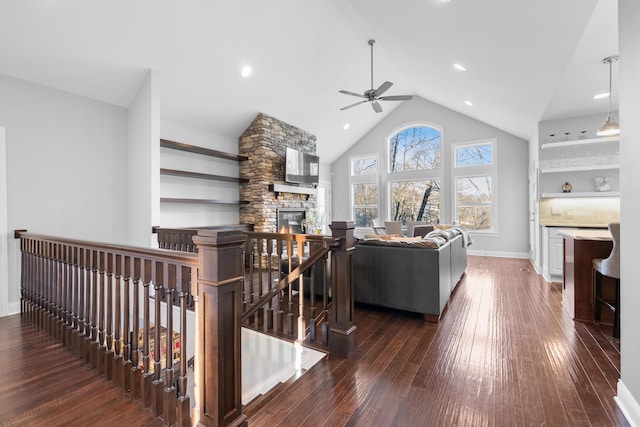 living room with a fireplace, dark wood-type flooring, ceiling fan, high vaulted ceiling, and baseboards