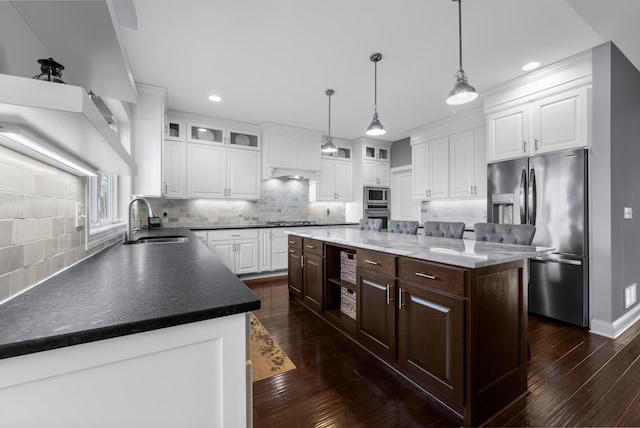 kitchen with dark brown cabinetry, dark wood-style flooring, a sink, white cabinets, and appliances with stainless steel finishes