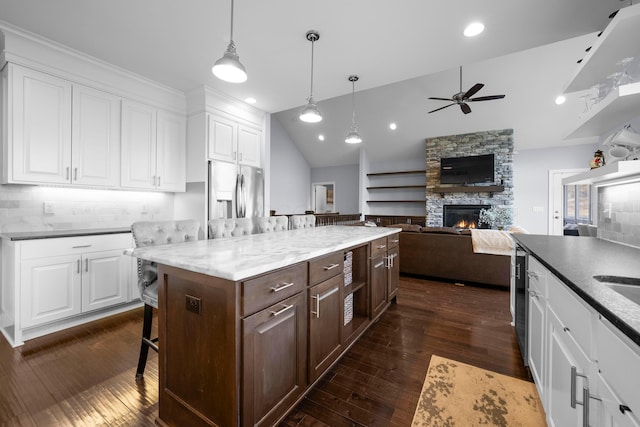 kitchen with a fireplace, dark wood-type flooring, white cabinetry, dark brown cabinetry, and stainless steel fridge with ice dispenser