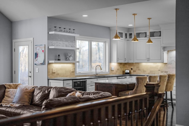 kitchen with tasteful backsplash, white cabinetry, and open floor plan