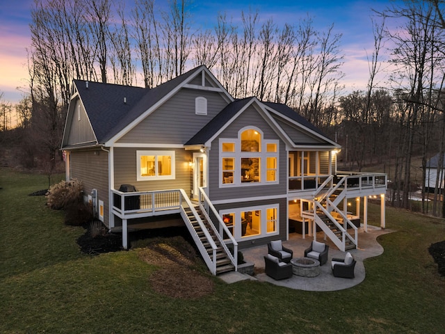 back of property at dusk with a patio, stairway, and a lawn