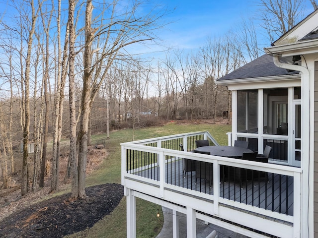 deck with a sunroom and outdoor dining area