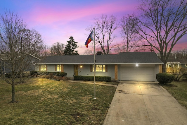 single story home featuring a garage and a lawn