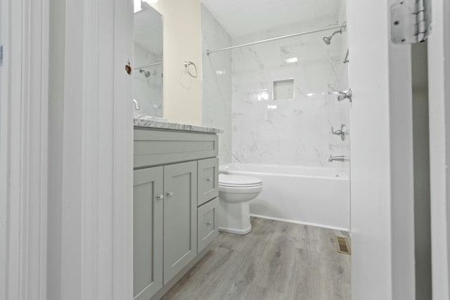 full bathroom with vanity, toilet, tiled shower / bath combo, and hardwood / wood-style floors