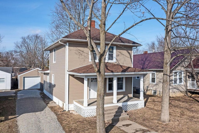 front of property featuring covered porch, a garage, and an outbuilding