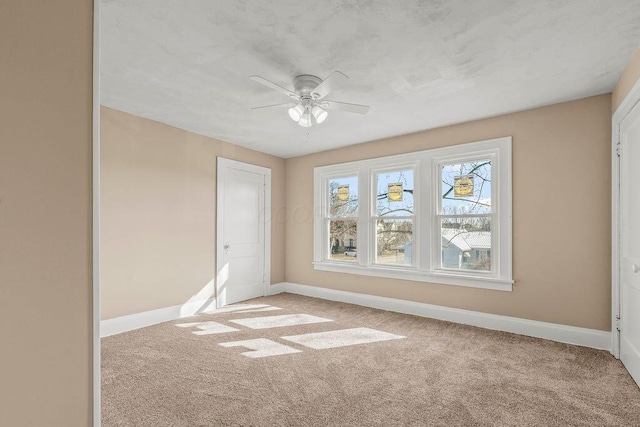 carpeted spare room featuring ceiling fan