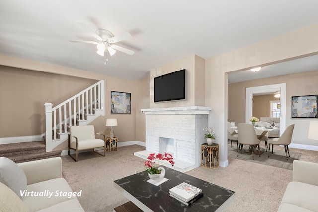 carpeted living room with a brick fireplace and ceiling fan