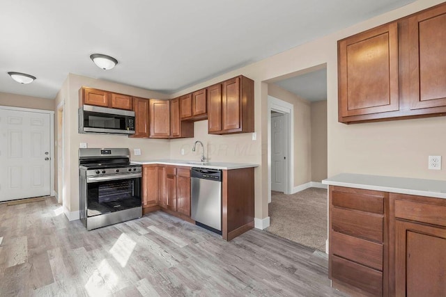 kitchen featuring appliances with stainless steel finishes, sink, and light hardwood / wood-style floors