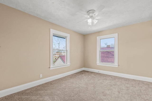 unfurnished room with ceiling fan, carpet flooring, and a textured ceiling