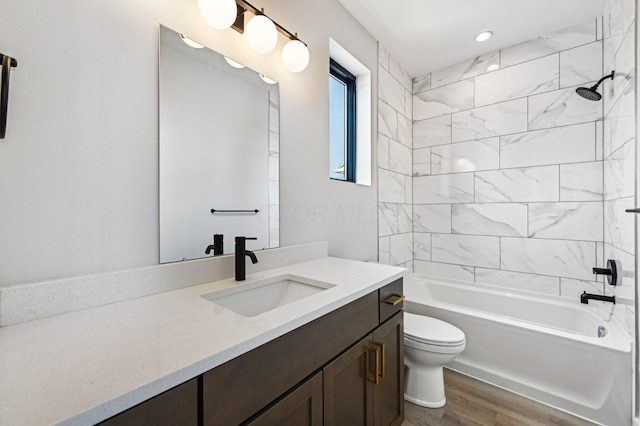 bathroom with wood finished floors, shower / bath combination, vanity, and toilet