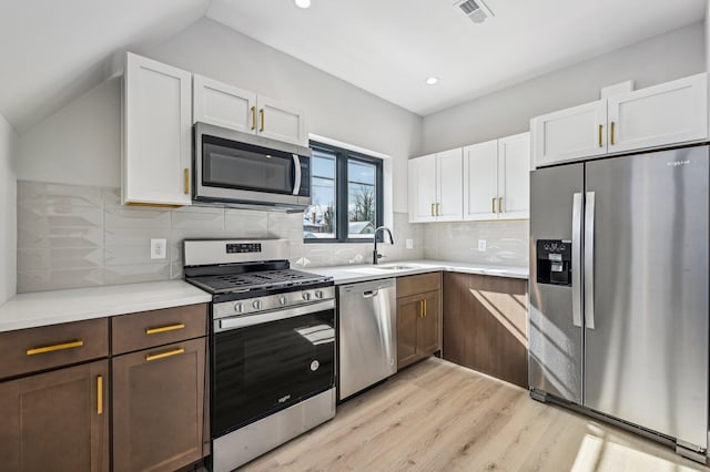 kitchen featuring visible vents, appliances with stainless steel finishes, light countertops, white cabinetry, and backsplash