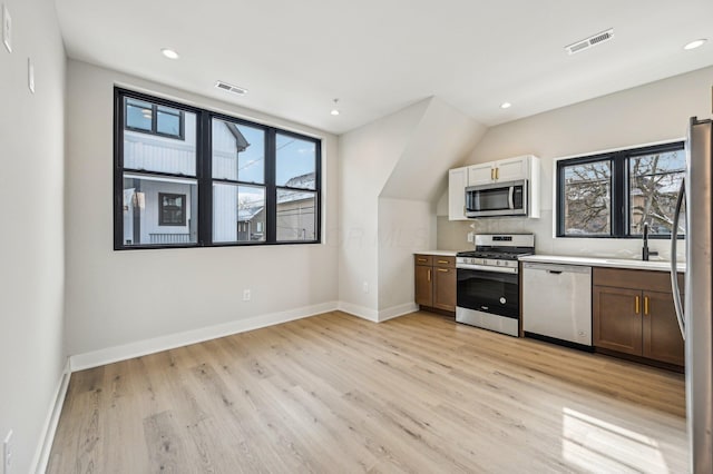 kitchen with light wood-style floors, visible vents, stainless steel appliances, and light countertops