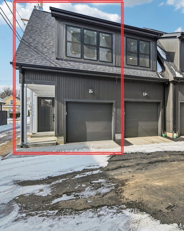 view of front of property featuring a garage and a shingled roof