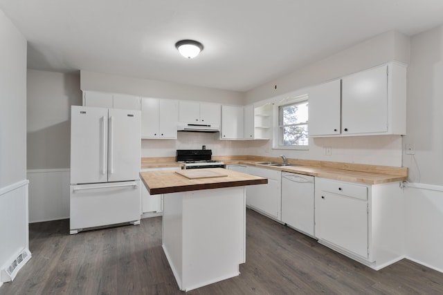 kitchen featuring butcher block counters, sink, white cabinetry, a kitchen island, and white appliances