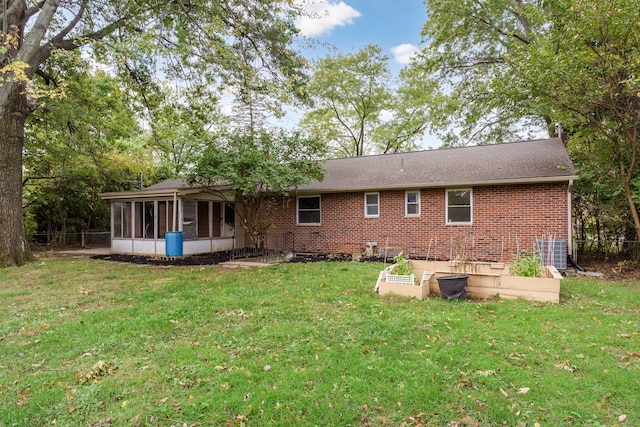 rear view of house featuring a sunroom, a yard, and central air condition unit