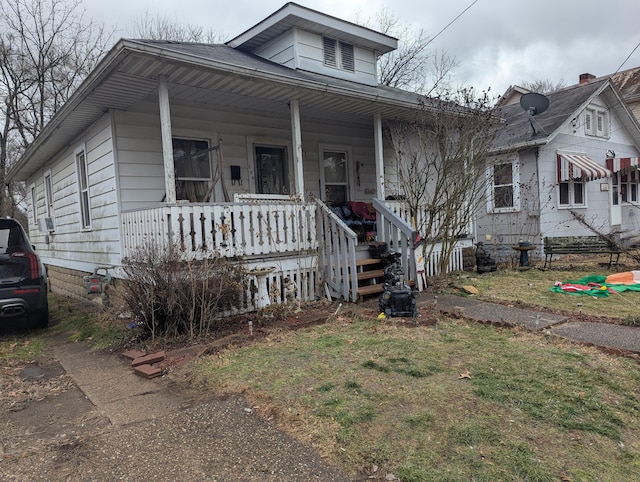 bungalow with covered porch and a front yard