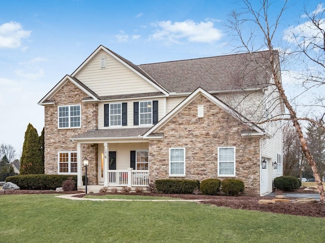 view of front of home with a garage, a front lawn, and covered porch