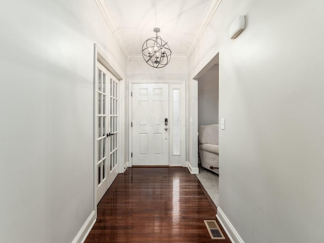 doorway featuring ornamental molding, dark hardwood / wood-style flooring, and a chandelier