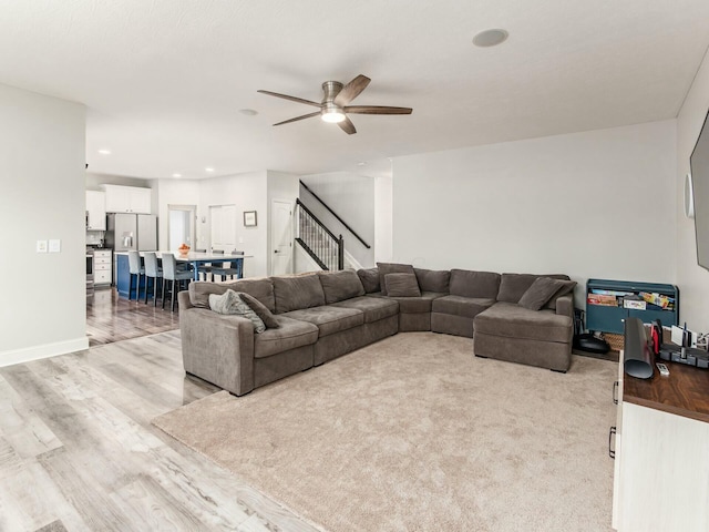 living room featuring light hardwood / wood-style flooring and ceiling fan