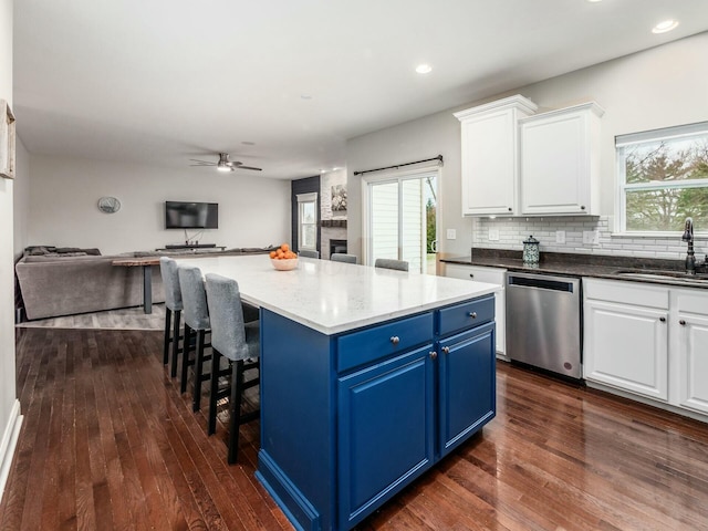 kitchen featuring blue cabinetry, dishwasher, sink, and white cabinets