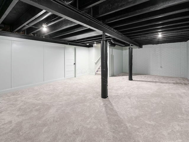 basement with brick wall and carpet