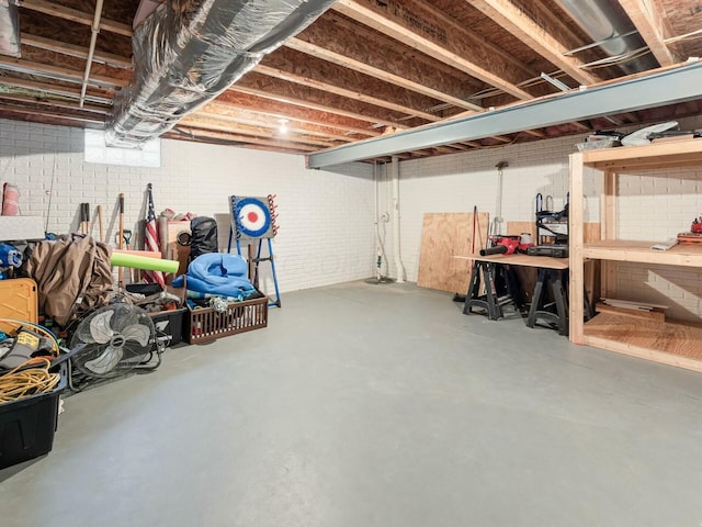 basement with brick wall and a workshop area